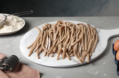 Photo of Uncooked homemade soba (buckwheat noodles) and ingredients on grey table