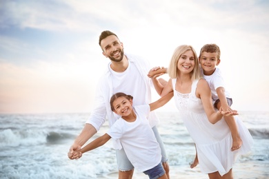 Photo of Happy family having fun on beach near sea