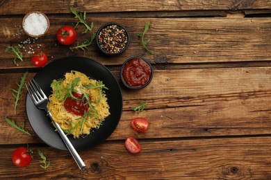 Photo of Tasty spaghetti squash with tomato sauce, cheese and arugula served on wooden table, flat lay. Space for text