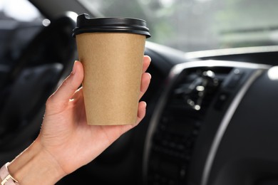 Coffee to go. Woman with paper cup of drink in car, closeup and space for text