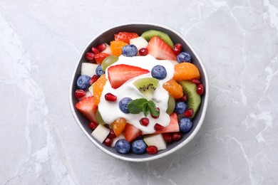 Delicious fruit salad on grey table, top view
