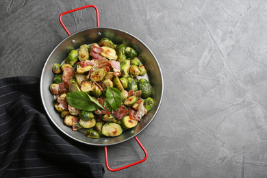 Delicious roasted Brussels sprouts with bacon on black table, top view