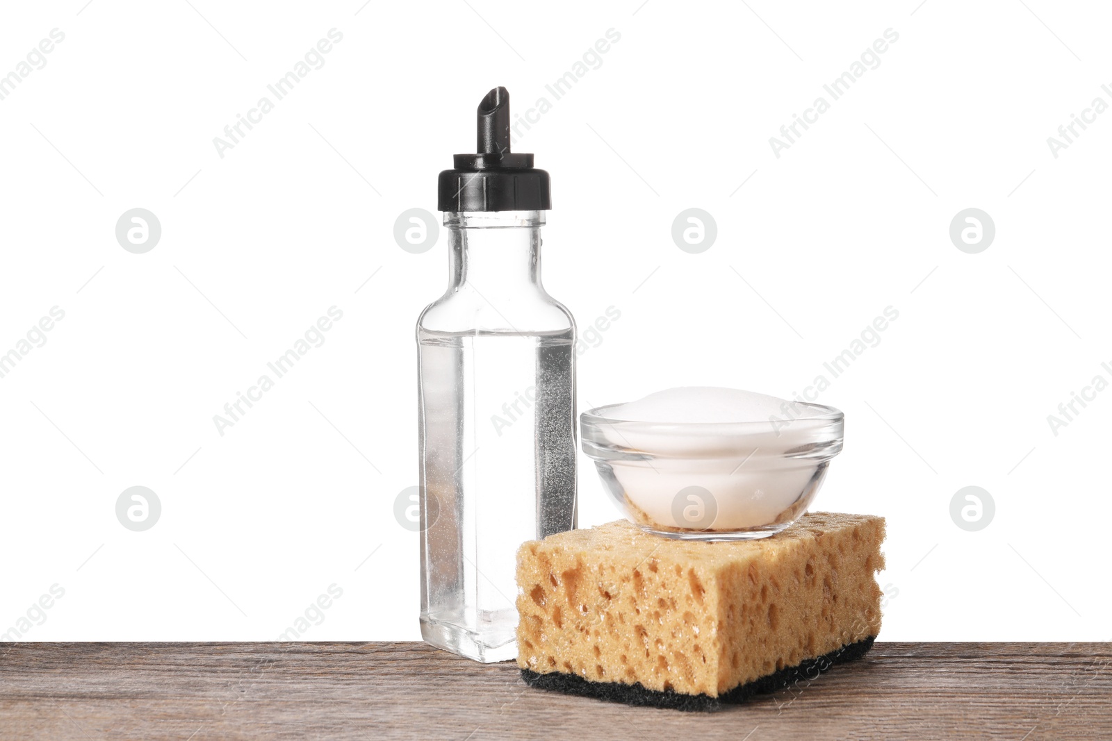 Photo of Natural cleaning products. Vinegar in bottle, baking soda and sponge on wooden table against white background