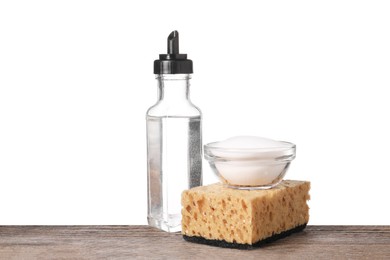 Natural cleaning products. Vinegar in bottle, baking soda and sponge on wooden table against white background