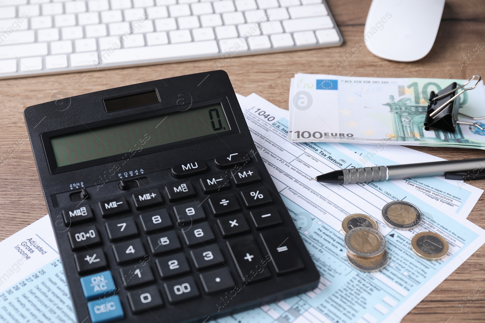 Photo of Tax accounting. Calculator, documents, money, keyboard and pen on wooden table, closeup