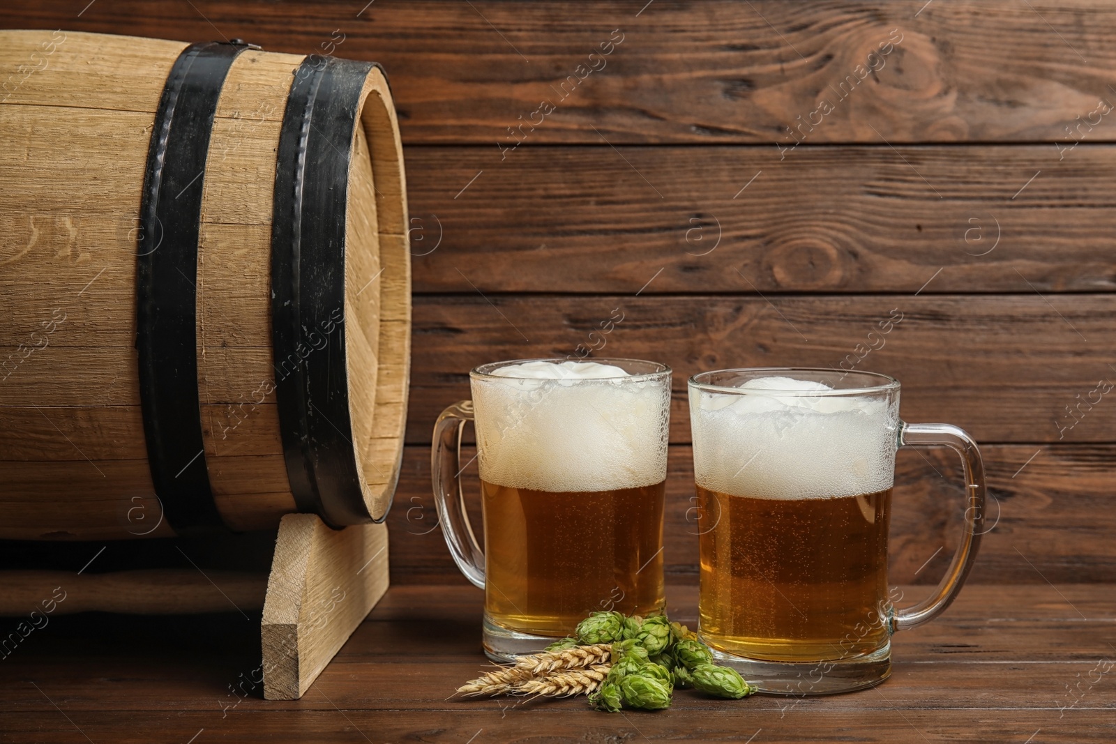 Photo of Composition with tasty beer and fresh green hops on wooden table