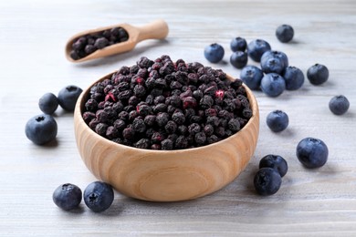 Photo of Freeze dried and fresh blueberries on white wooden table
