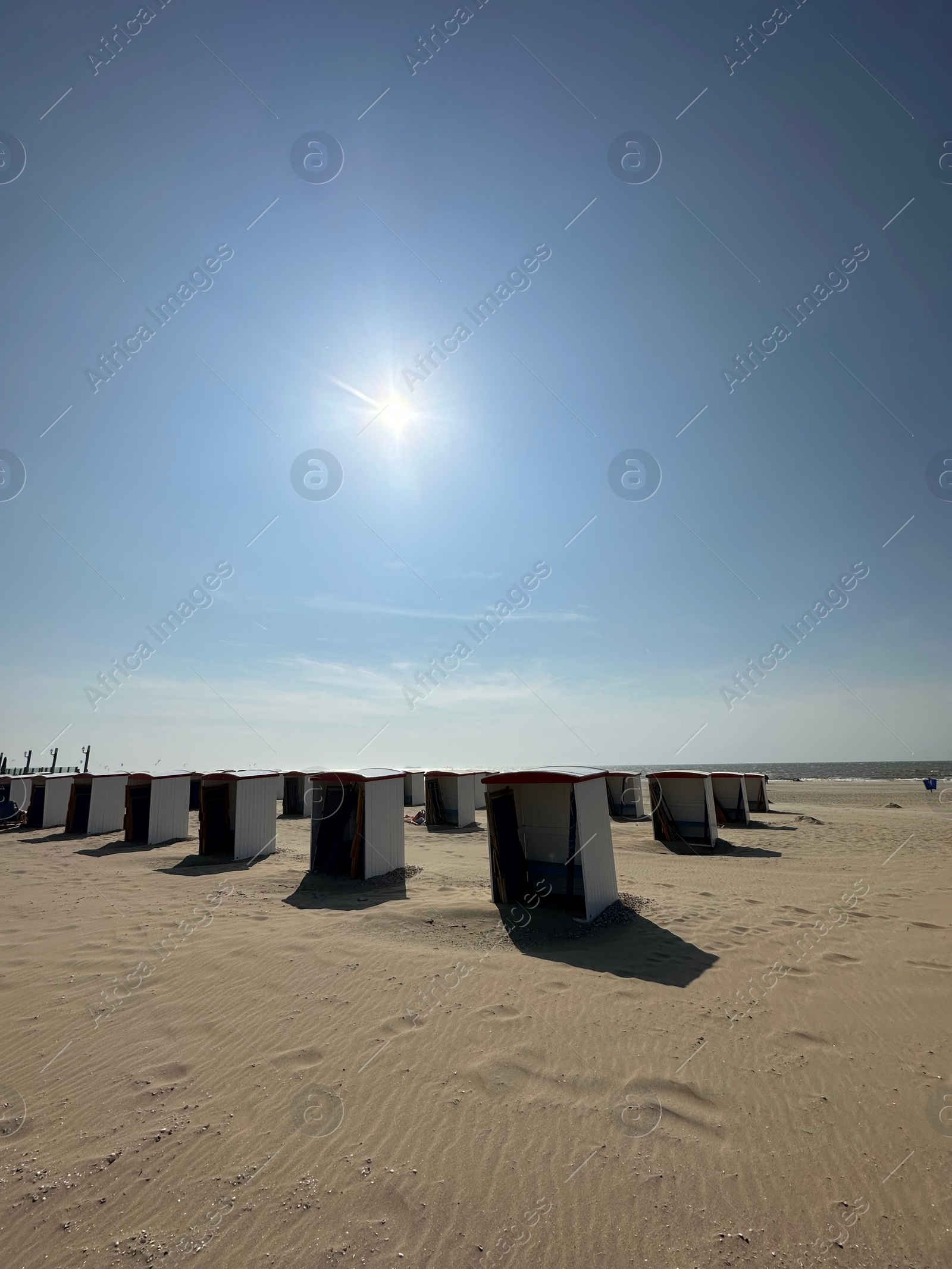 Photo of Many wooden beach huts on seacoast under blue sky