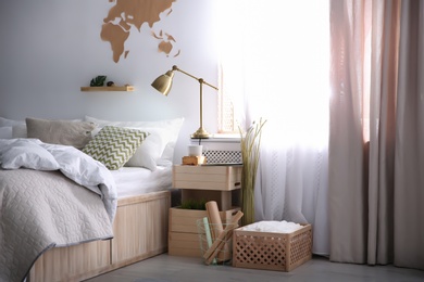 Photo of Modern eco style interior with wooden crates and comfortable bed