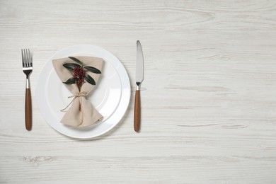 Stylish setting with elegant cutlery on white wooden table, top view. Space for text