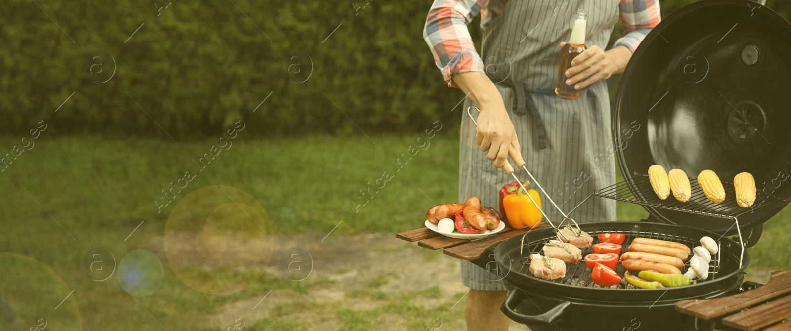 Image of Man having picnic and cooking food on barbecue grill outdoors, closeup with space for text. Banner design