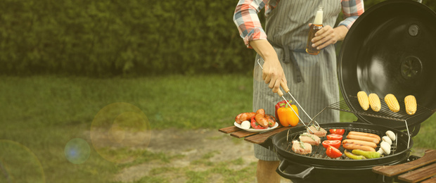 Image of Man having picnic and cooking food on barbecue grill outdoors, closeup with space for text. Banner design