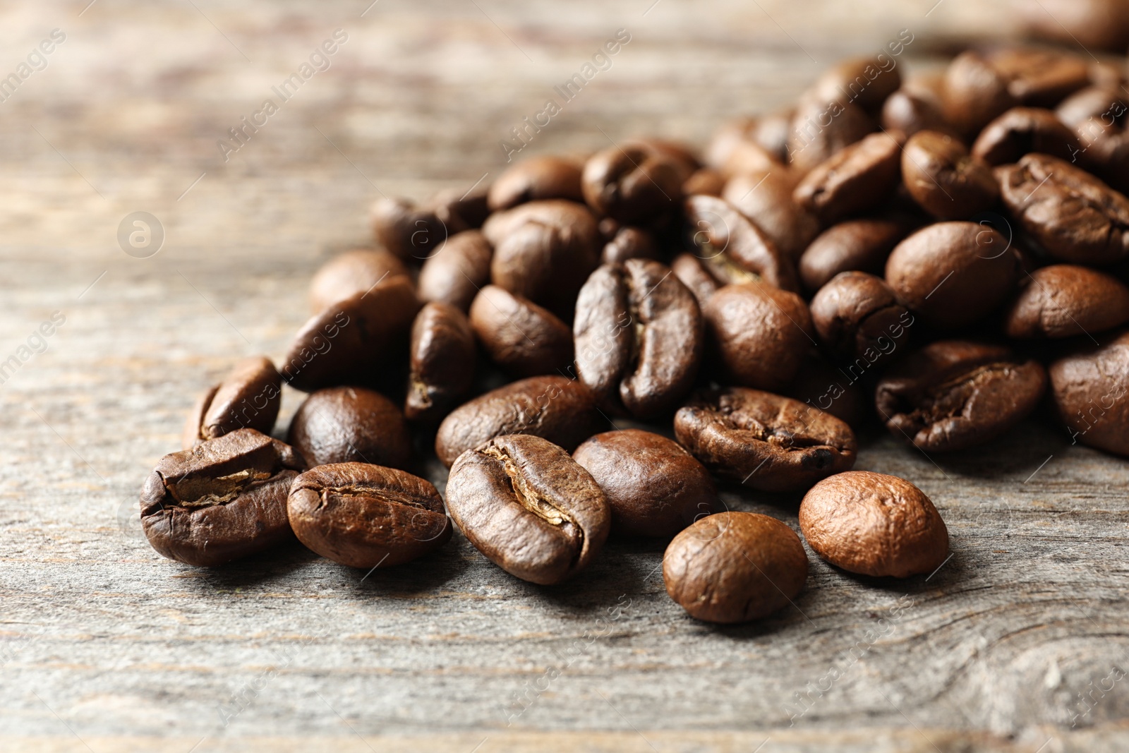 Photo of Roasted coffee beans on wooden background, closeup