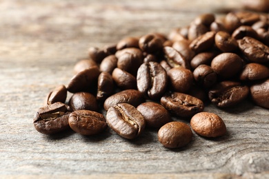 Roasted coffee beans on wooden background, closeup