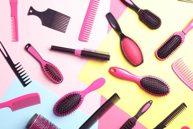Different hair brushes and combs on color background, flat lay