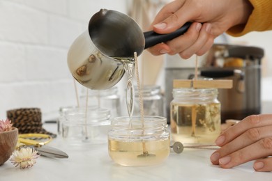 Woman making candles at white table, closeup