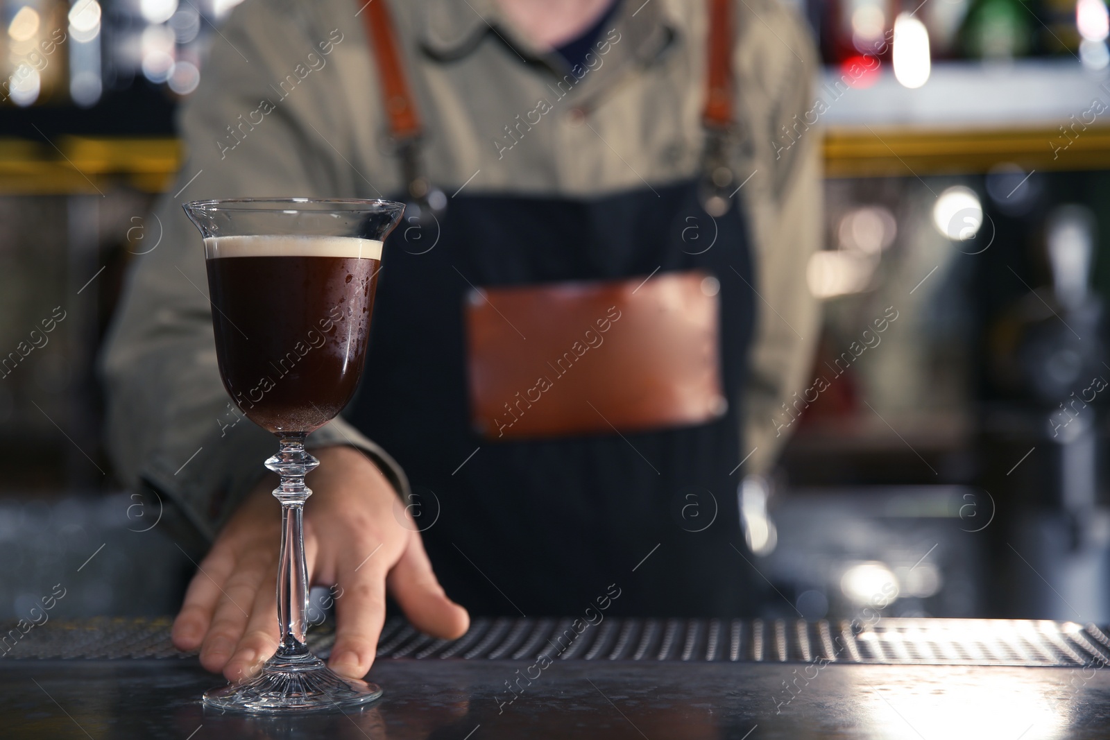 Photo of Barman serving espresso martini cocktail at counter, closeup. Space for text