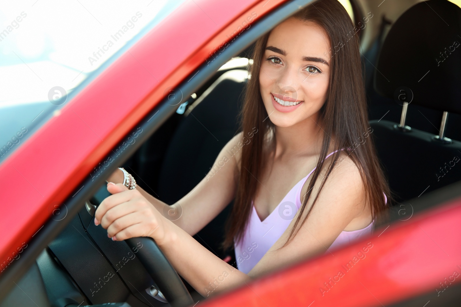 Photo of Young woman on driver's seat of car