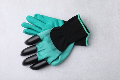 Photo of Pair of claw gardening gloves on light grey table, top view