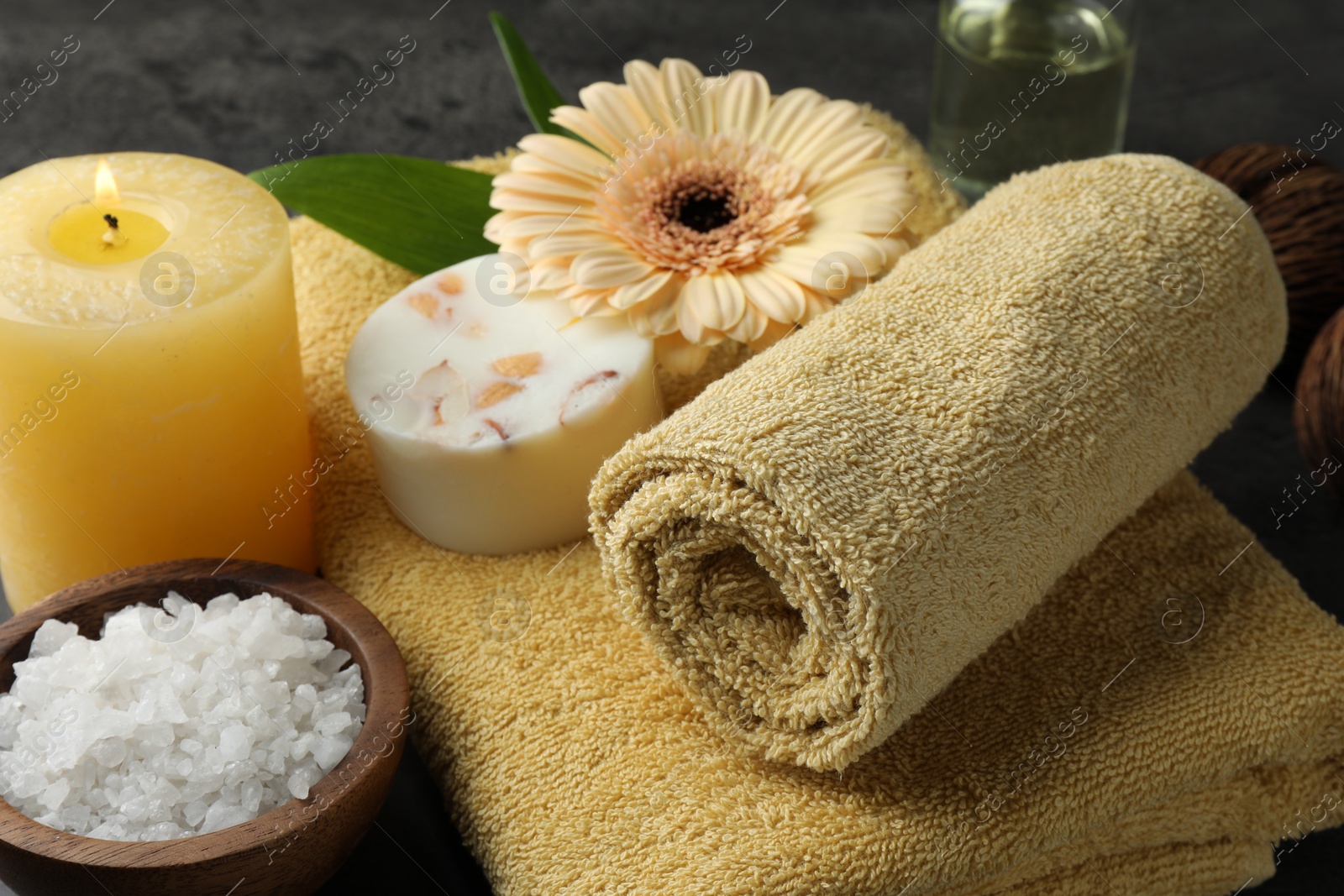 Photo of Composition with different spa products and burning candle on table, closeup