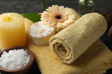 Photo of Composition with different spa products and burning candle on table, closeup