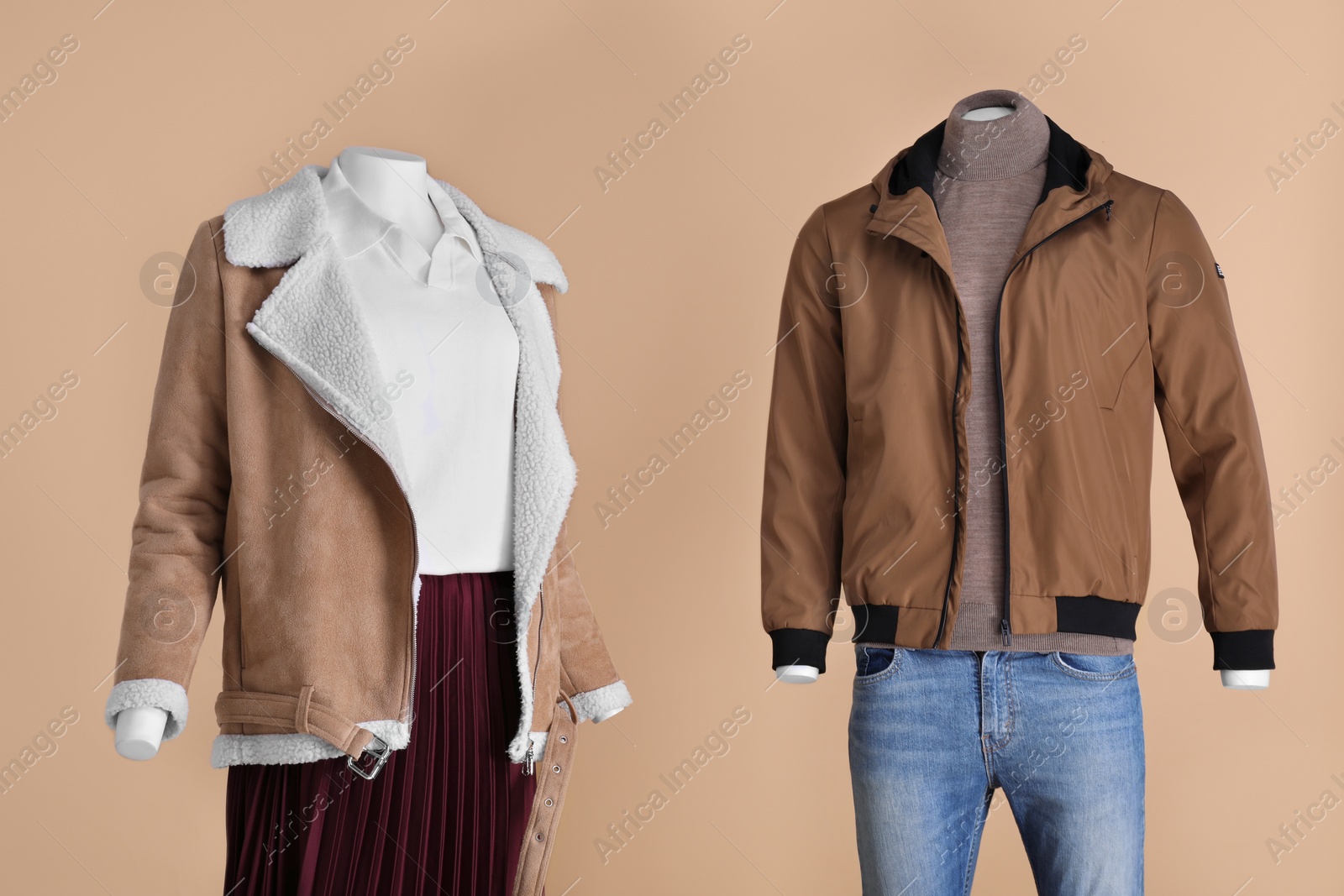 Photo of Female and male mannequins dressed in different clothes on beige background. Stylish outfits