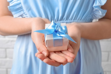 Photo of Woman holding beautiful gift box, closeup