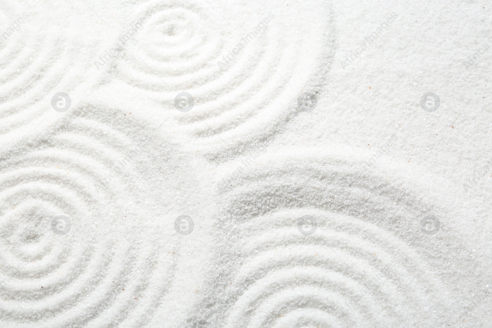 Photo of Zen rock garden. Circle patterns on white sand, closeup