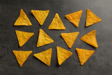Photo of Flat lay composition of tasty tortilla chips (nachos) on grey table
