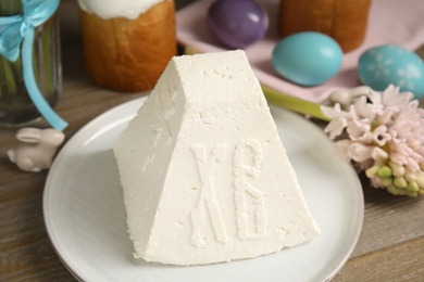 Photo of Traditional cottage cheese Easter paskha on wooden table, closeup