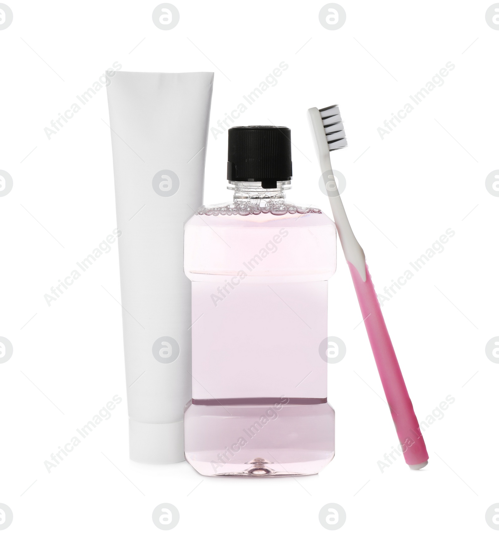 Photo of Bottle with mouthwash, toothbrush and paste on white background