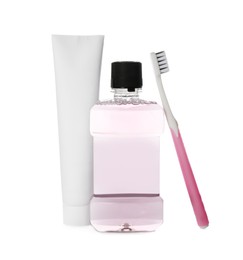 Bottle with mouthwash, toothbrush and paste on white background