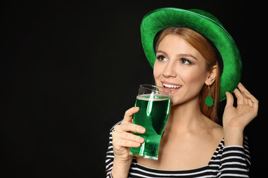 Young woman with green beer on black background. St. Patrick's Day celebration