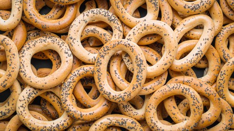 Photo of Many delicious ring shaped Sushki (dry bagels) as background, top view
