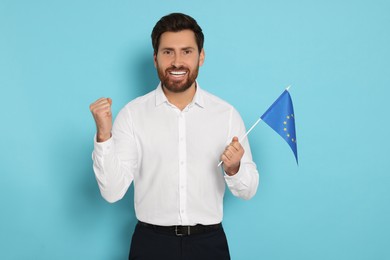 Man with flag of European Union on light blue background