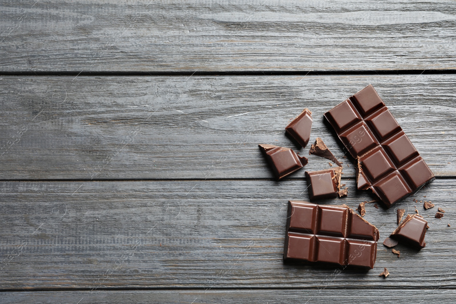 Photo of Tasty chocolate on wooden background, flat lay. Space for text