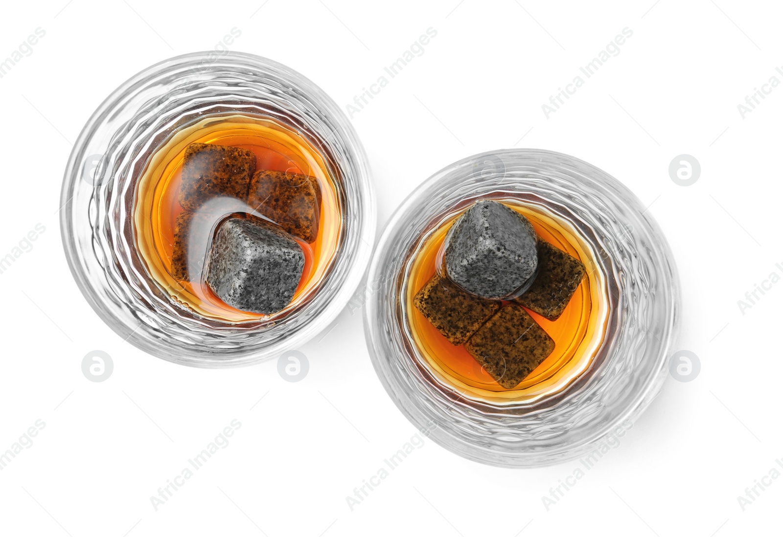 Photo of Glasses with liquor and whiskey stones on white background, top view