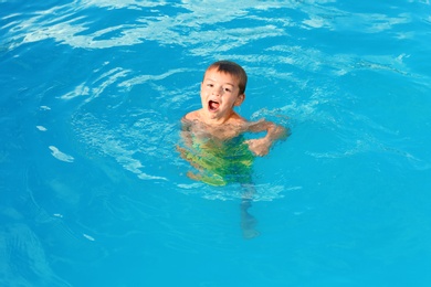 Photo of Little child in outdoor swimming pool. Dangerous situation