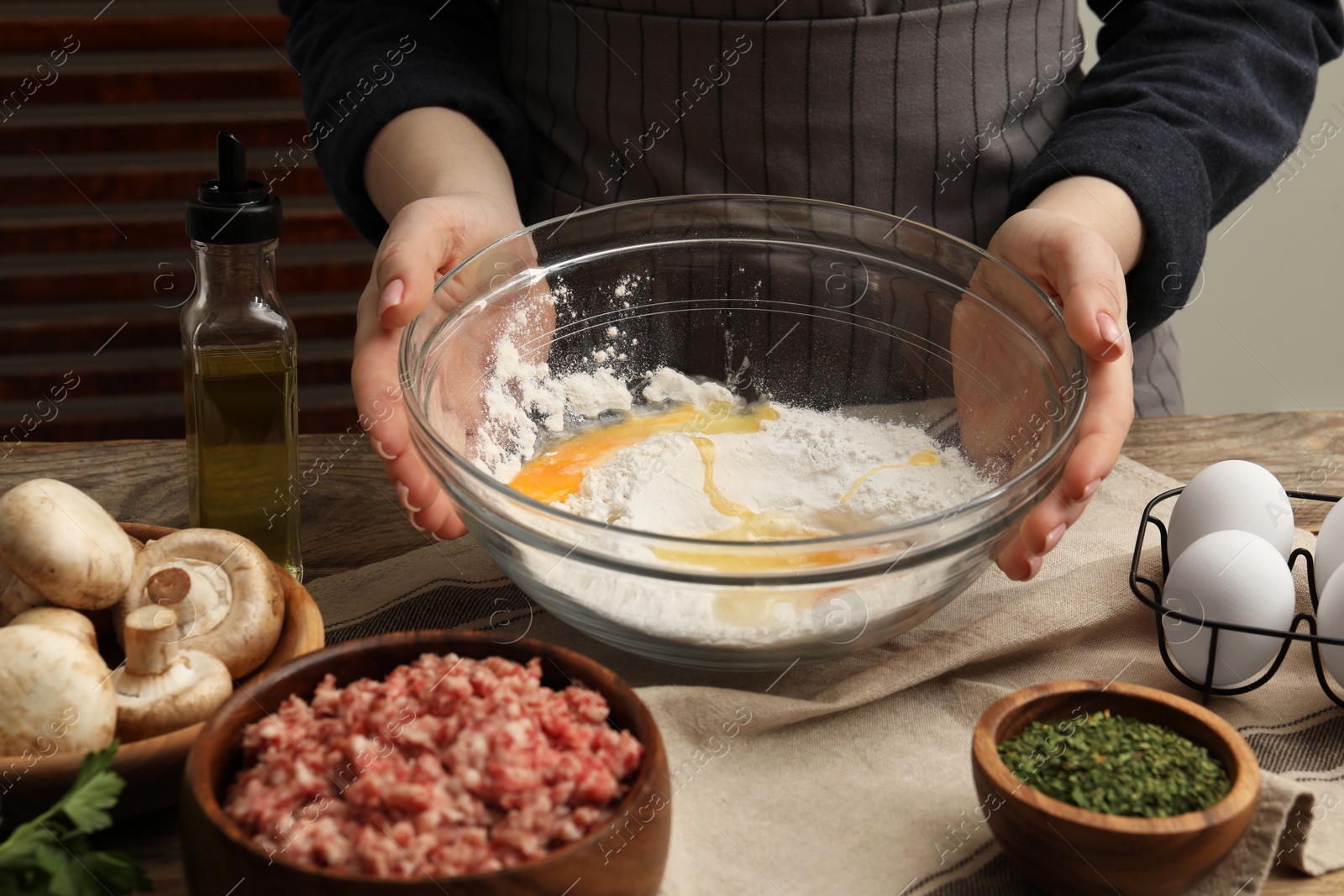 Photo of Woman making dough at wooden table, closeup