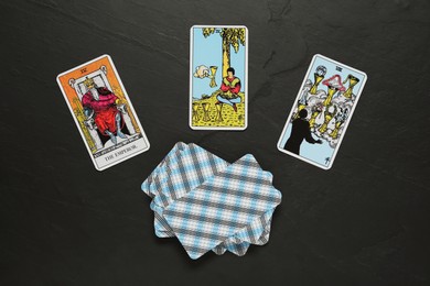 Photo of Tarot cards on black table, flat lay