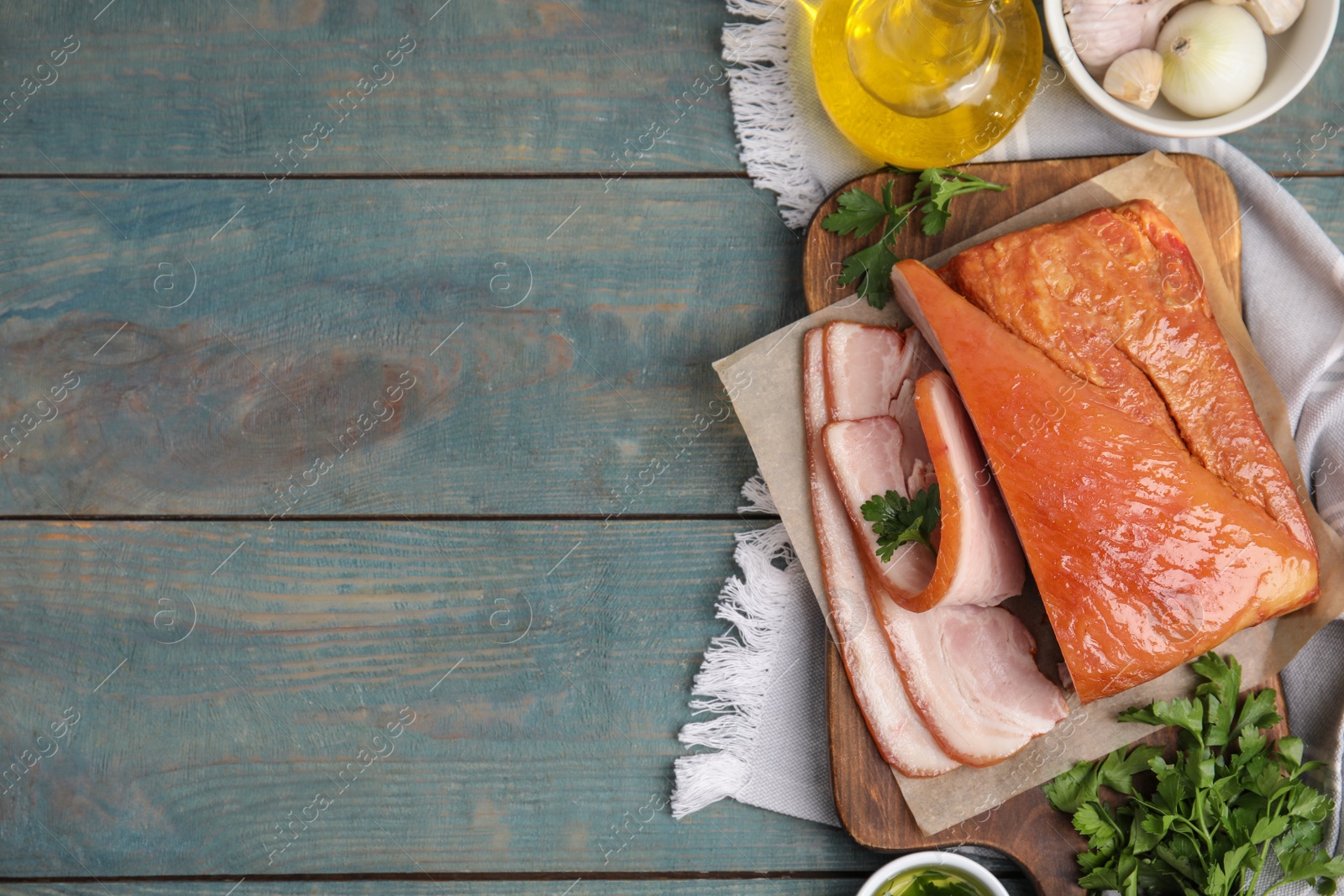 Photo of Flat lay composition with delicious smoked bacon on light blue wooden table, space for text