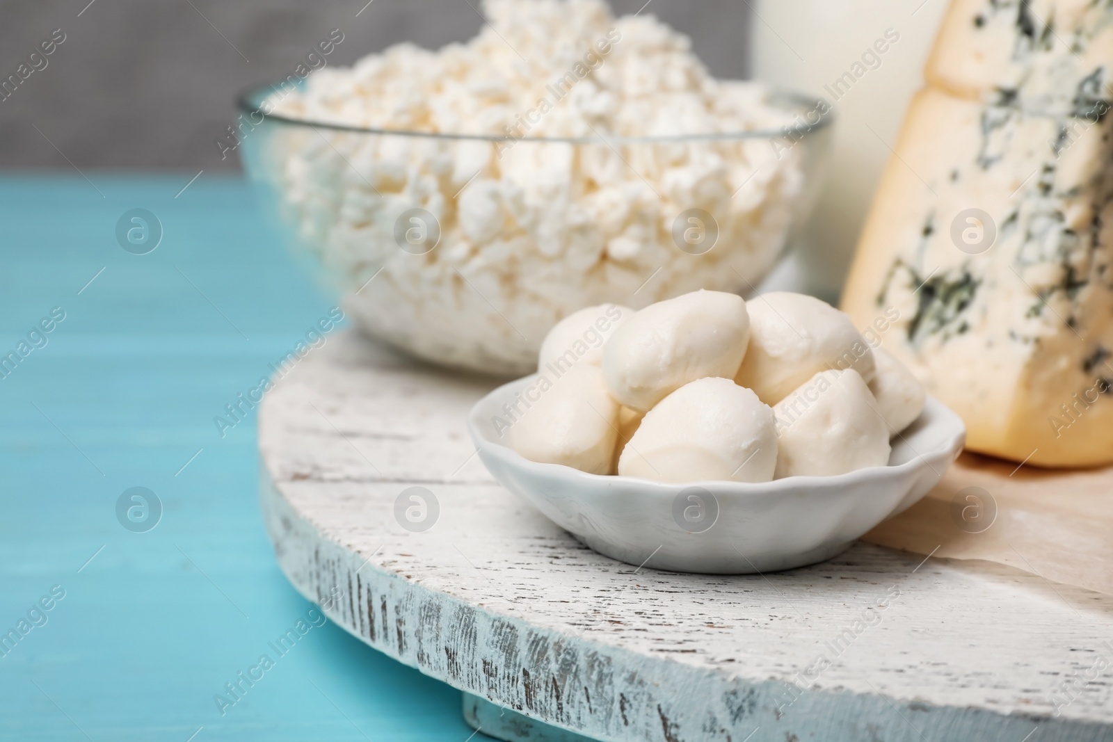 Photo of Plate with fresh mozzarella balls on wooden table. Dairy products