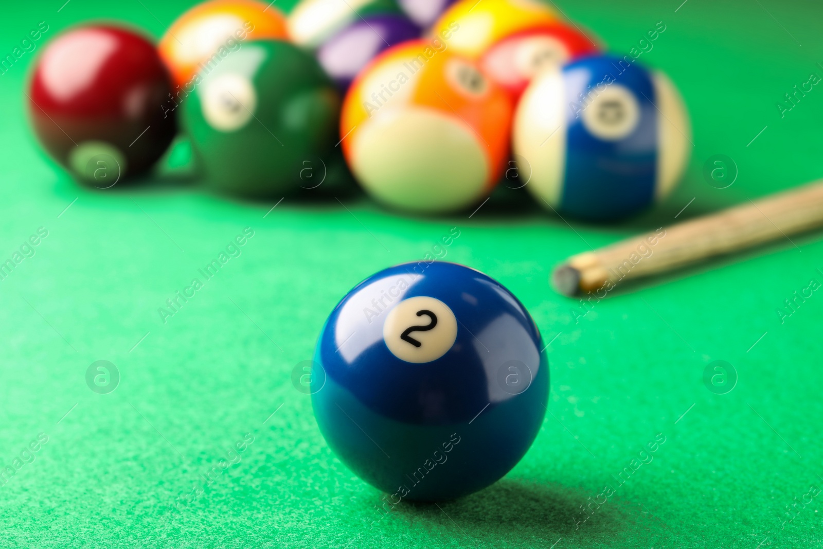 Photo of Billiard ball with number 2 on green table, closeup