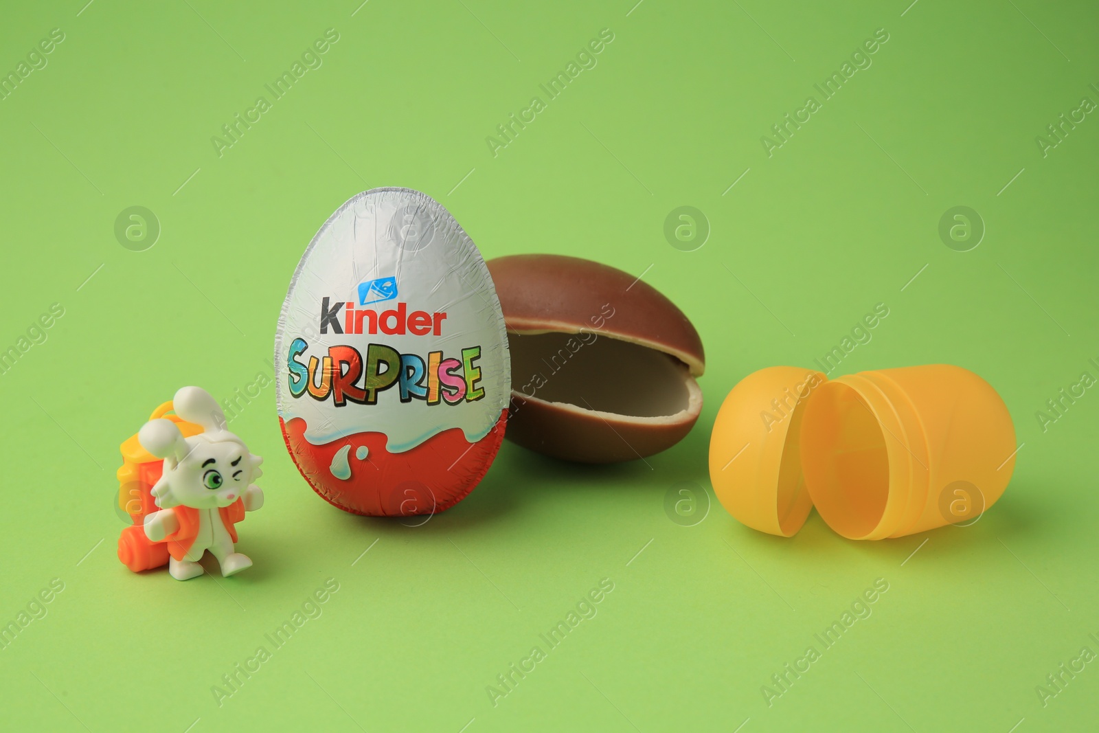Photo of Sveti Vlas, Bulgaria - June 29, 2023: Kinder Surprise Eggs, plastic capsule and toy bunny on light green background