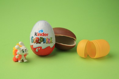 Sveti Vlas, Bulgaria - June 29, 2023: Kinder Surprise Eggs, plastic capsule and toy bunny on light green background