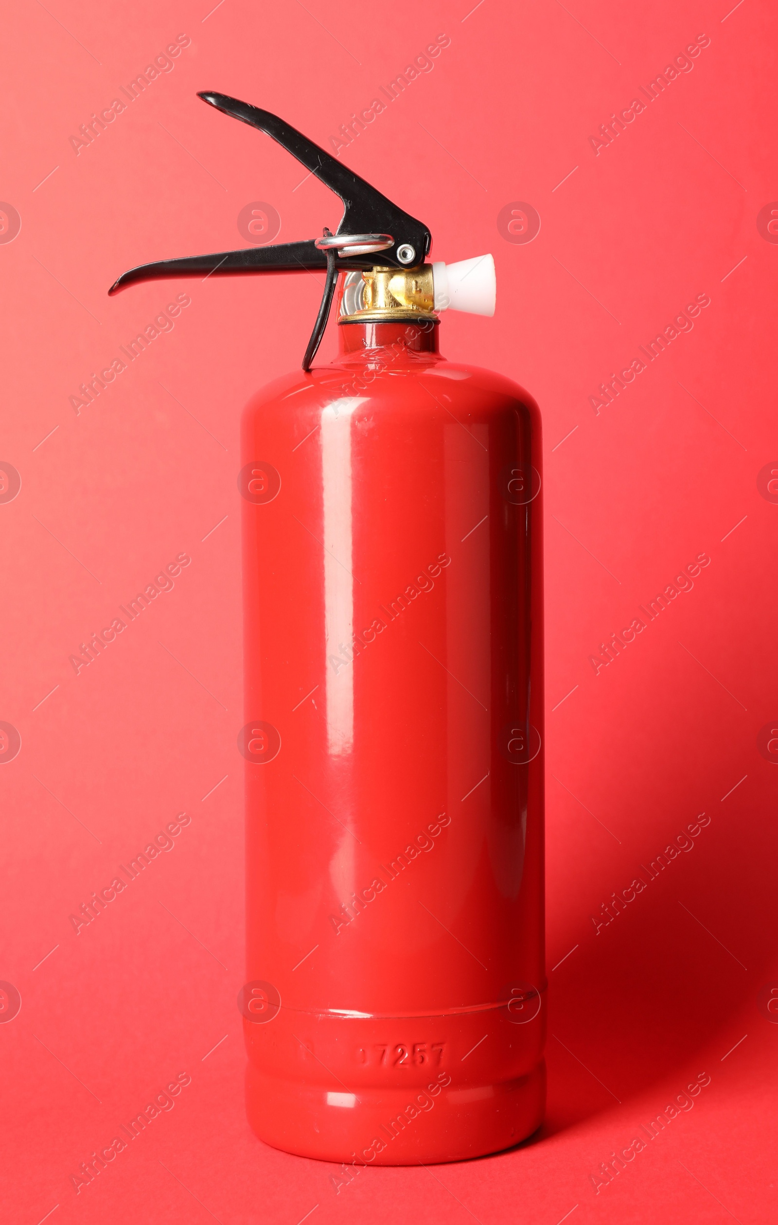 Photo of One fire extinguisher on red background. Safety equipment