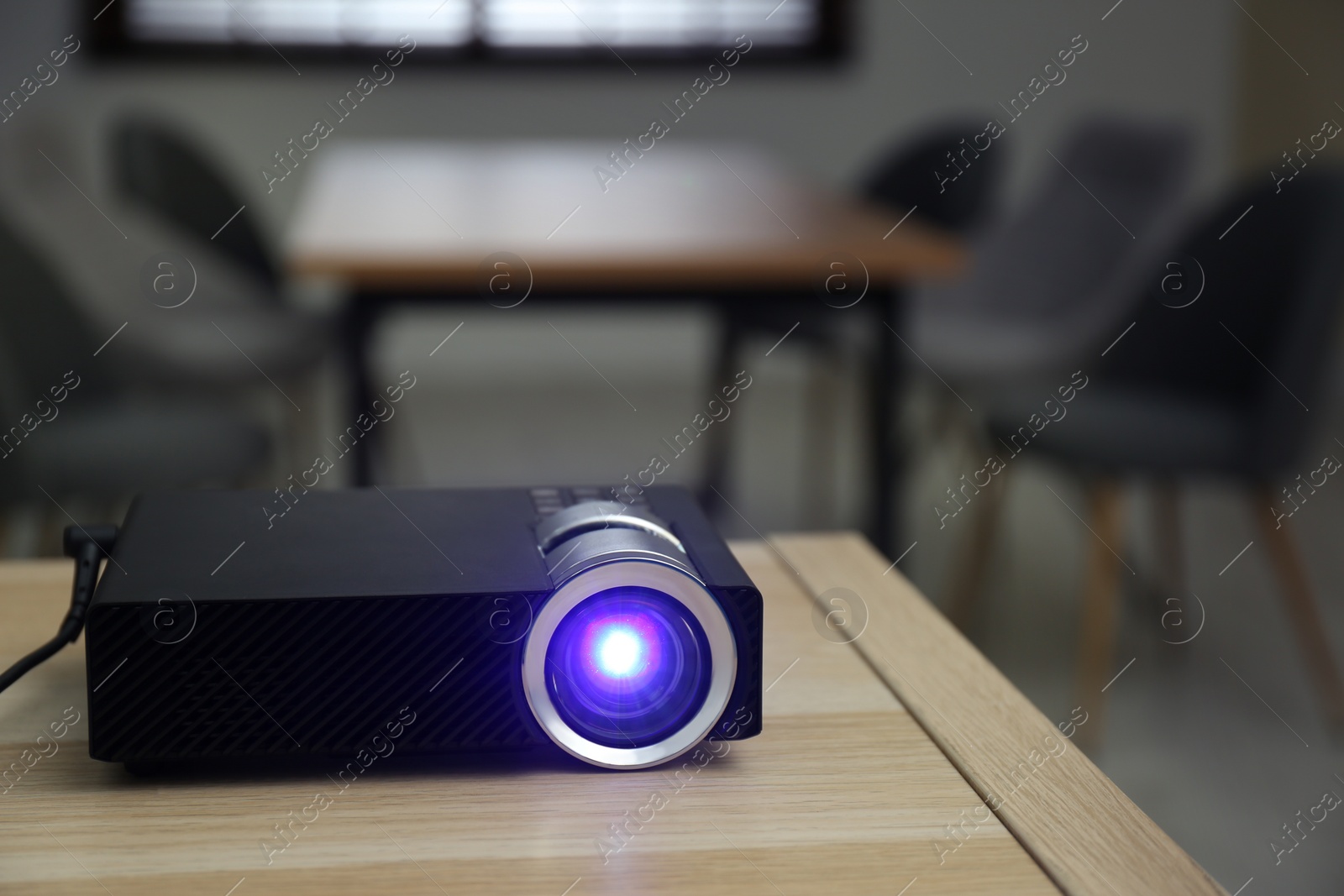 Photo of Modern video projector on wooden table in conference room