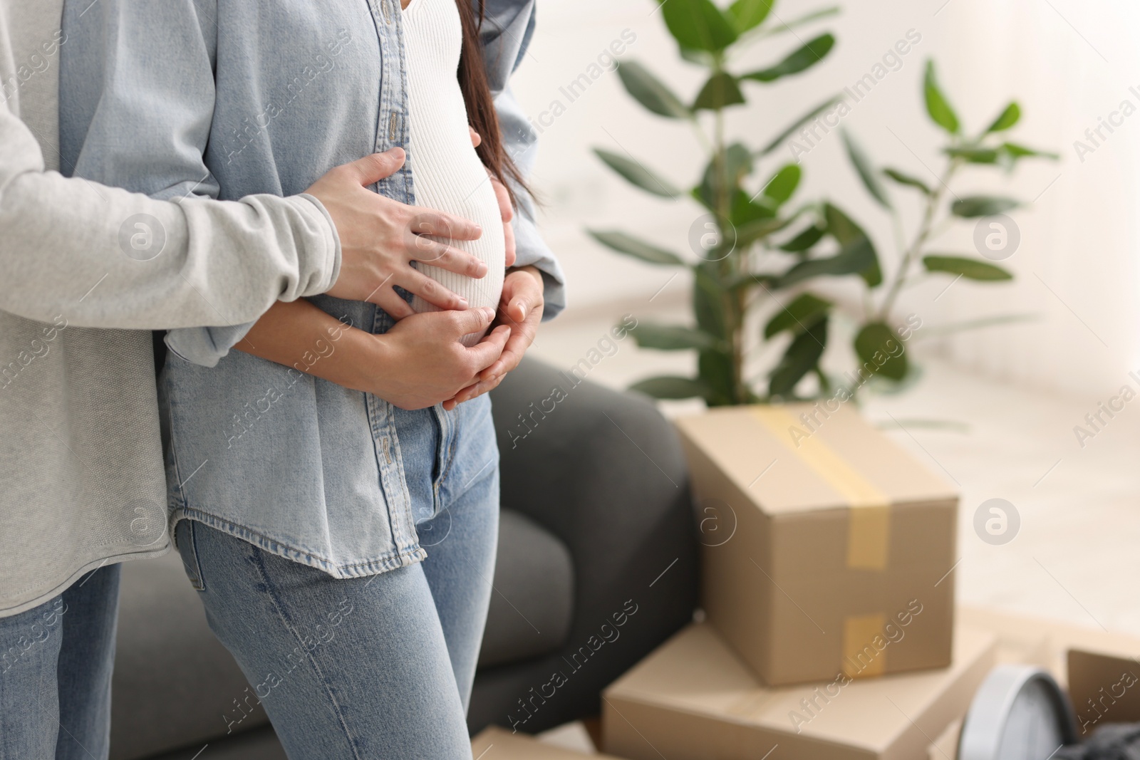 Photo of Pregnant woman and her husband in their new apartment, closeup. Space for text