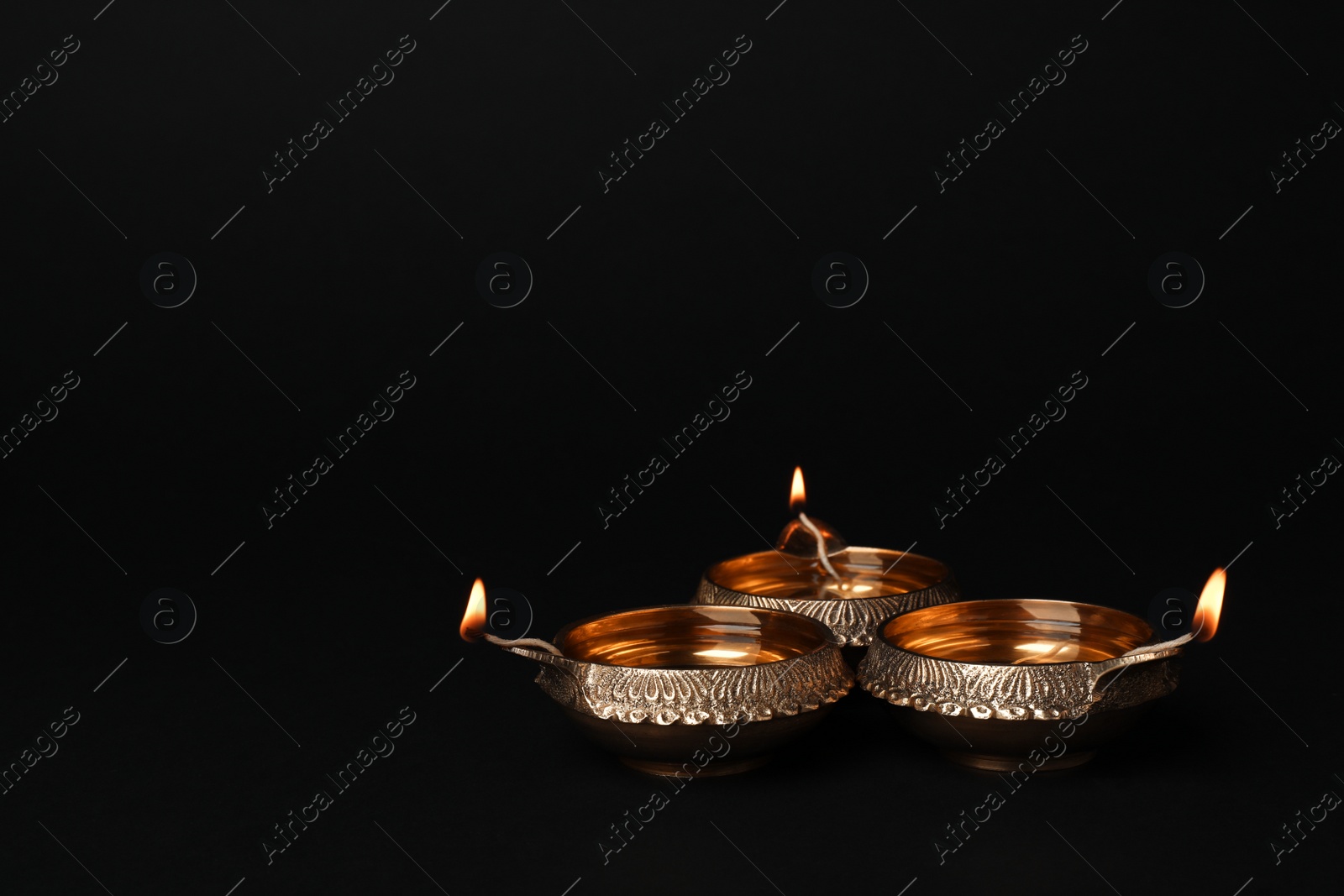 Photo of Diwali diyas or clay lamps on dark background