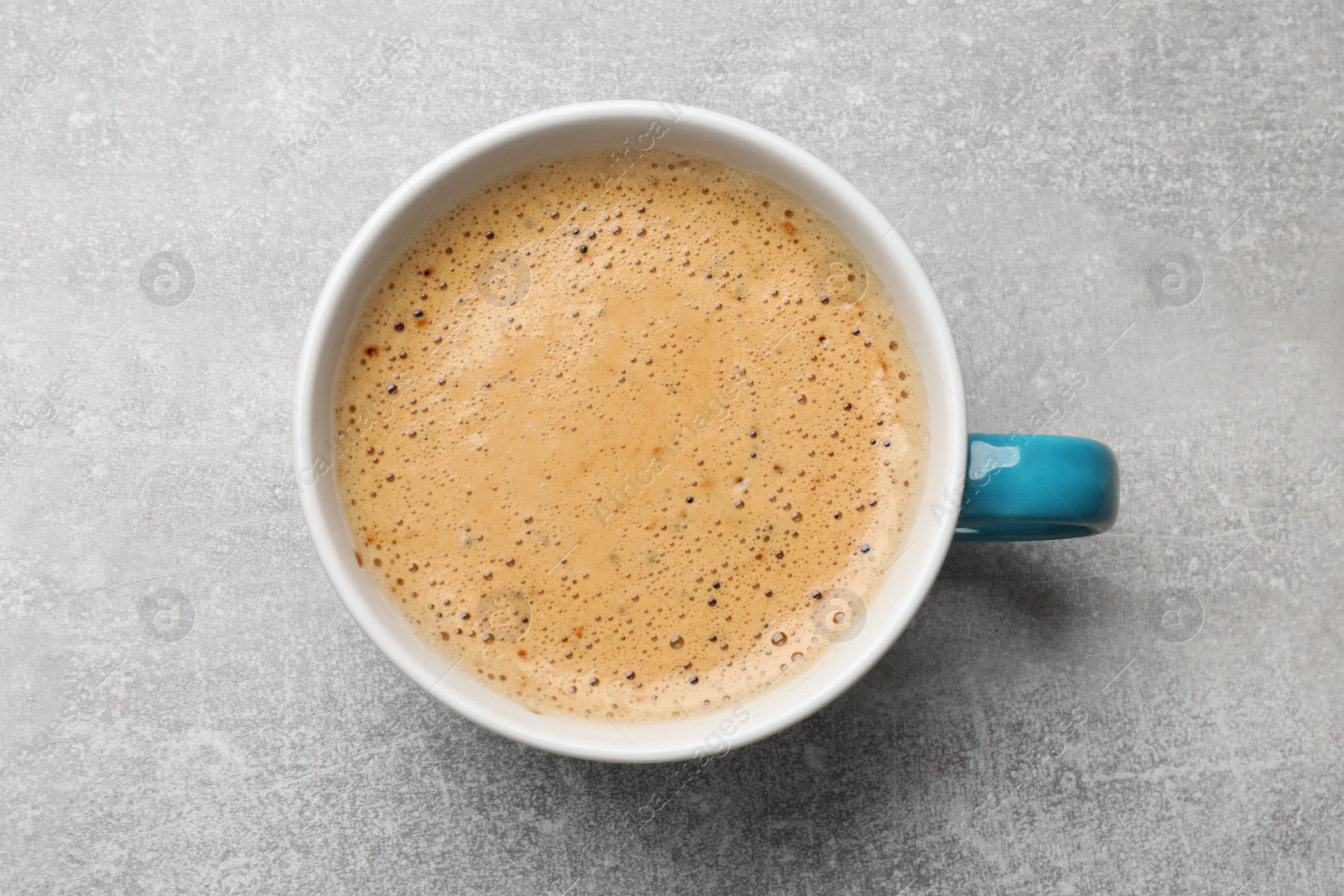 Photo of Cup of aromatic coffee on light grey table, top view